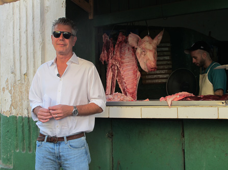 Anthony Bourdain in front of butcher stand, Cuba