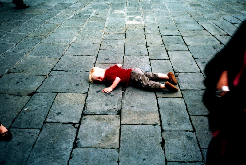 Child lying on ground outside