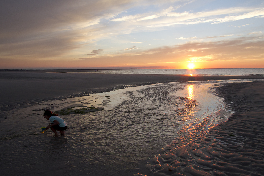 Young girl combing the beach at sunset in Cape Cod, Massachusetts