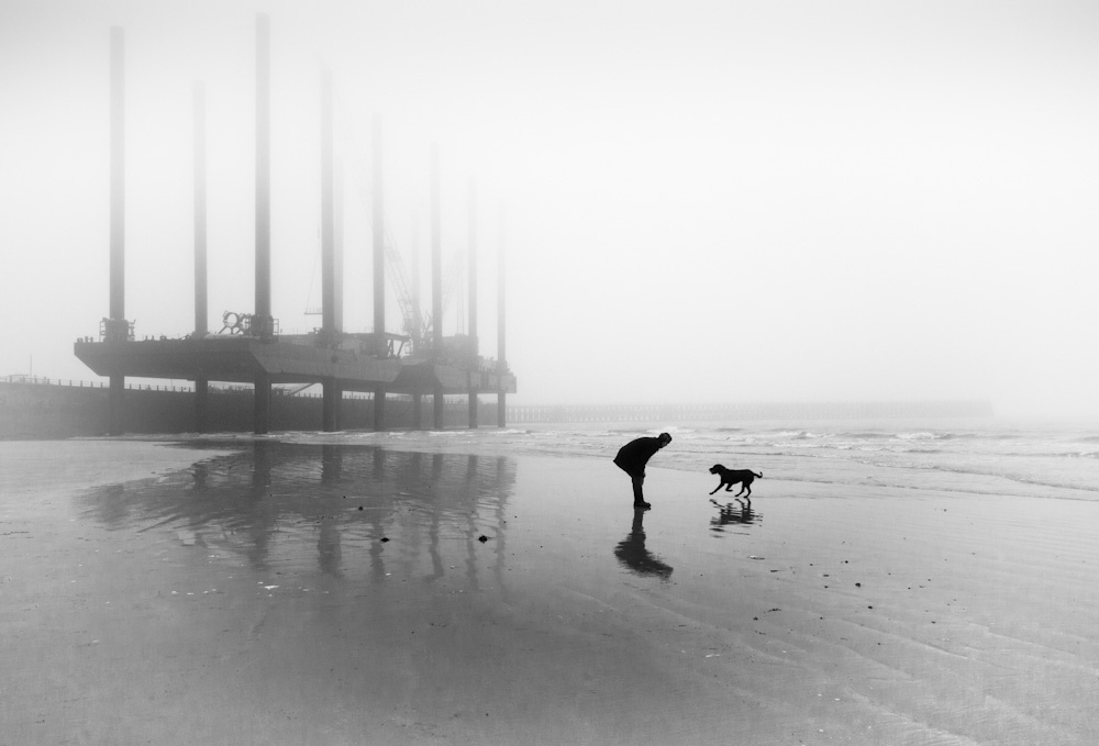 One man and his dog, Newhaven Beach, Sussex, UK