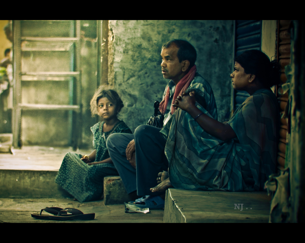 Indian family of three looking hopeful/pensive