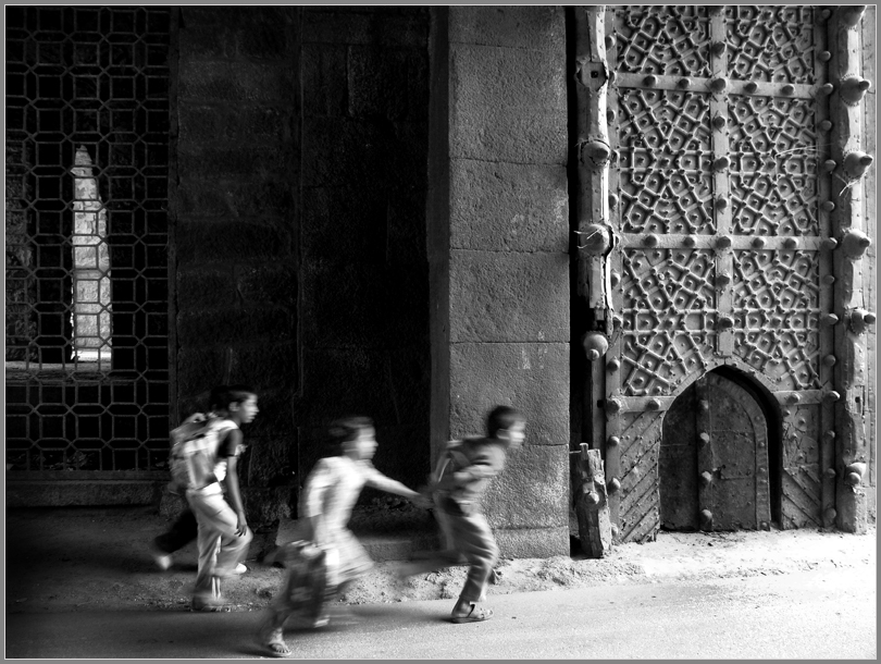 Children running through the gate of Golkonda Fort, Hyderabad, India