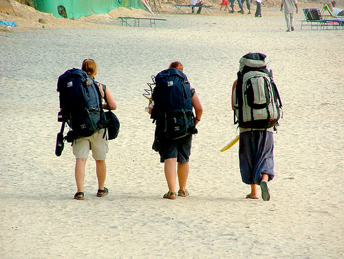 Three backpackers on beach in India