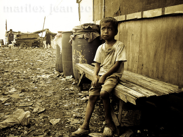 Boy on bench, pondering in Manila